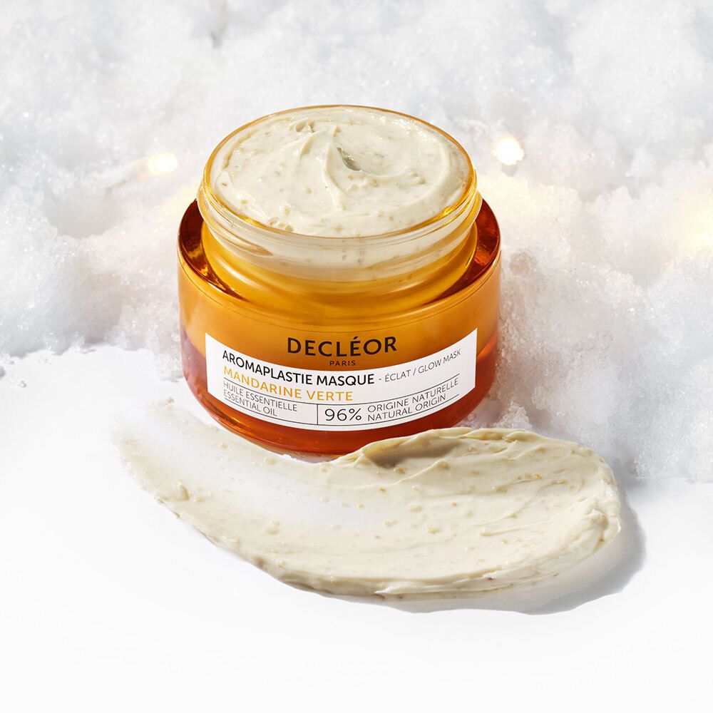 Pot de masque facial et application. Masque clair, pot orange. Inscription : DECLÉOR, Aromaplastie Masque, 96% origine naturelle.
