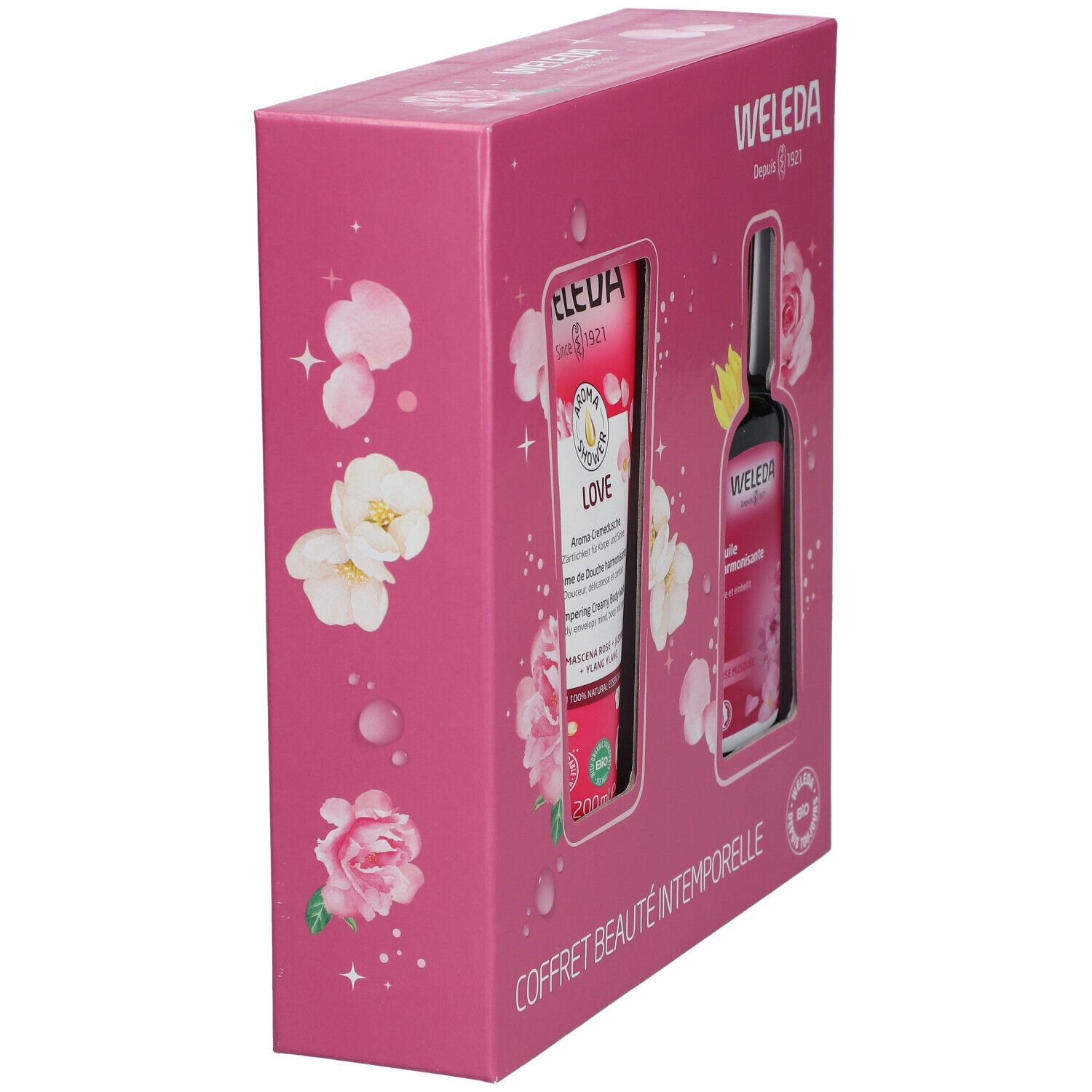 Coffret rose en biais avec deux produits. Inscriptions: WELEDA, COFFRET BEAUTÉ INTEMPORELLE.