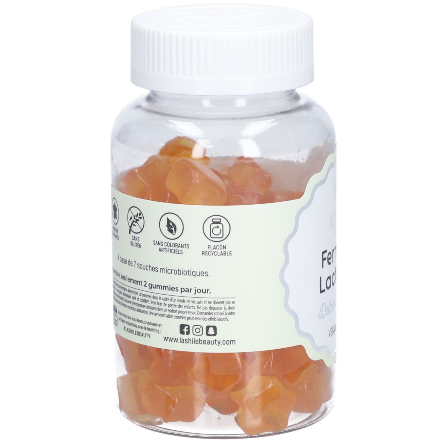 Flacon transparent avec gummies oranges. Étiquette : "Ferments Lactiques". Logos : sans gluten, sans colorants artificiels.