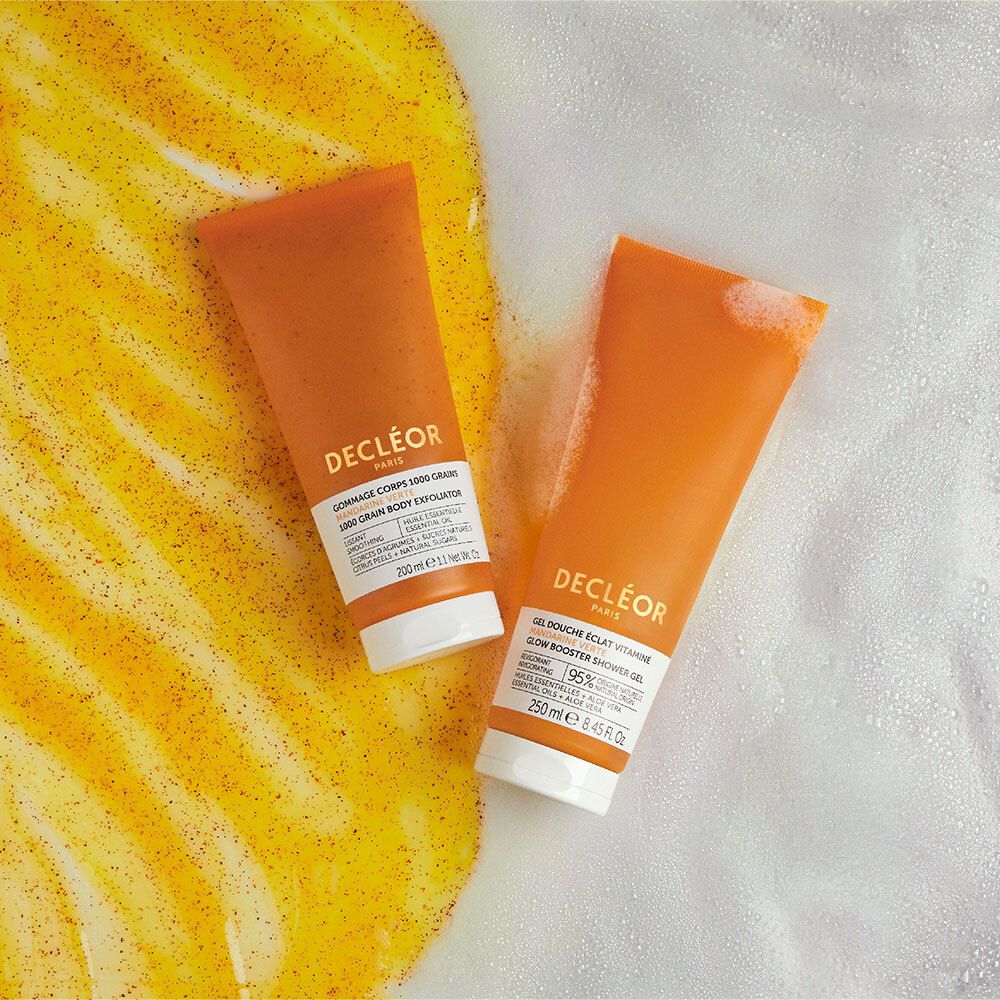 Deux tubes DECLÉOR orange. Inscription Gommage Corps. Posés sur de la mousse.