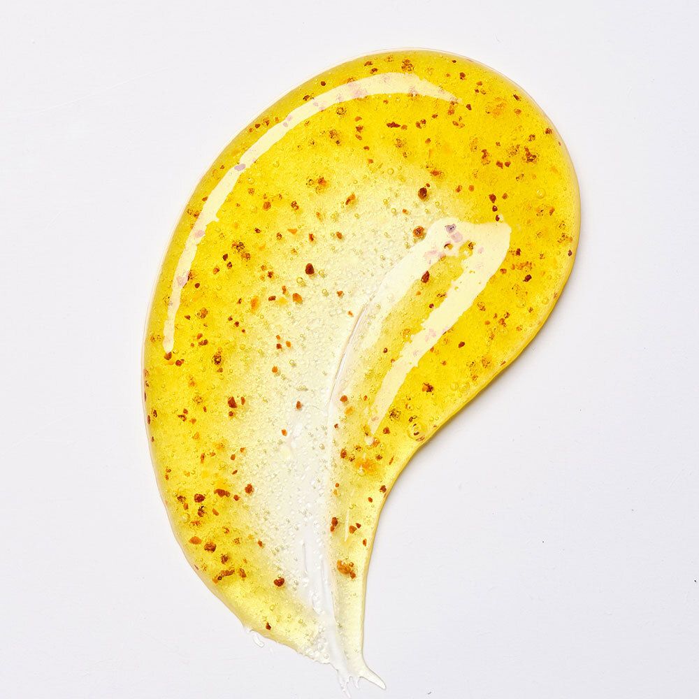 Substance jaune avec particules brunes. Étendue sur fond blanc.