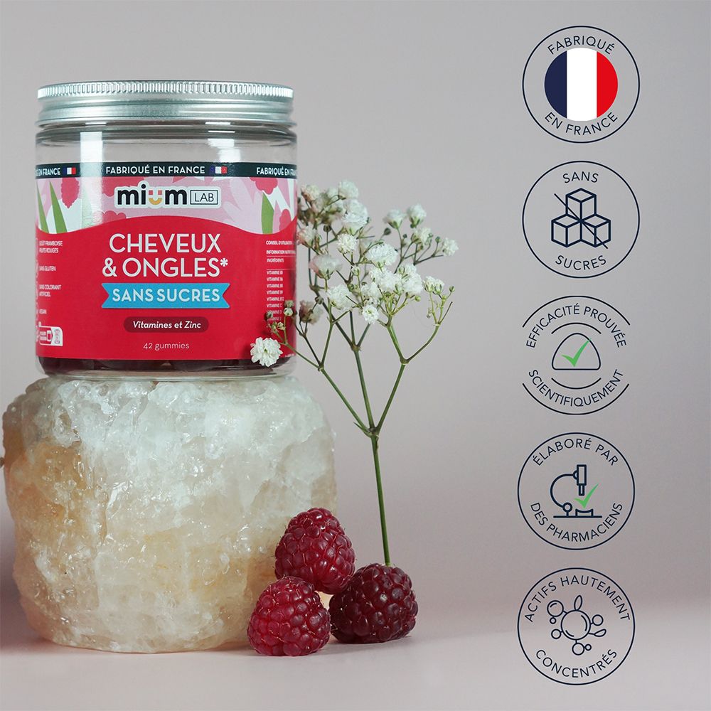 Pot avec étiquette rouge: Cheveux & Ongles, Sans Sucres. Placé sur une pierre, avec des framboises. Texte: Fabriqué en France.