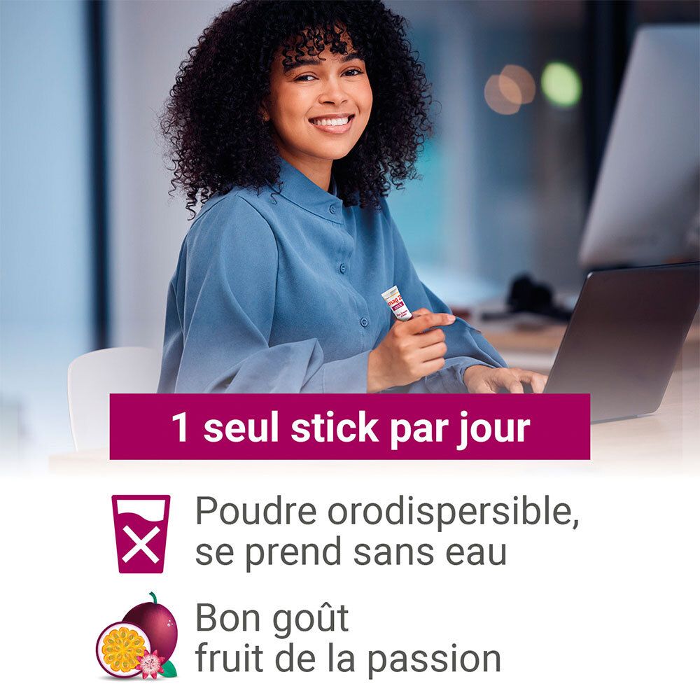 Frau am Schreibtisch mit Mag 2 Stick. Text: 1 Stick pro Tag. Orodissolvierbares Pulver, ohne Wasser. Guter Geschmack nach Passionsfrucht.