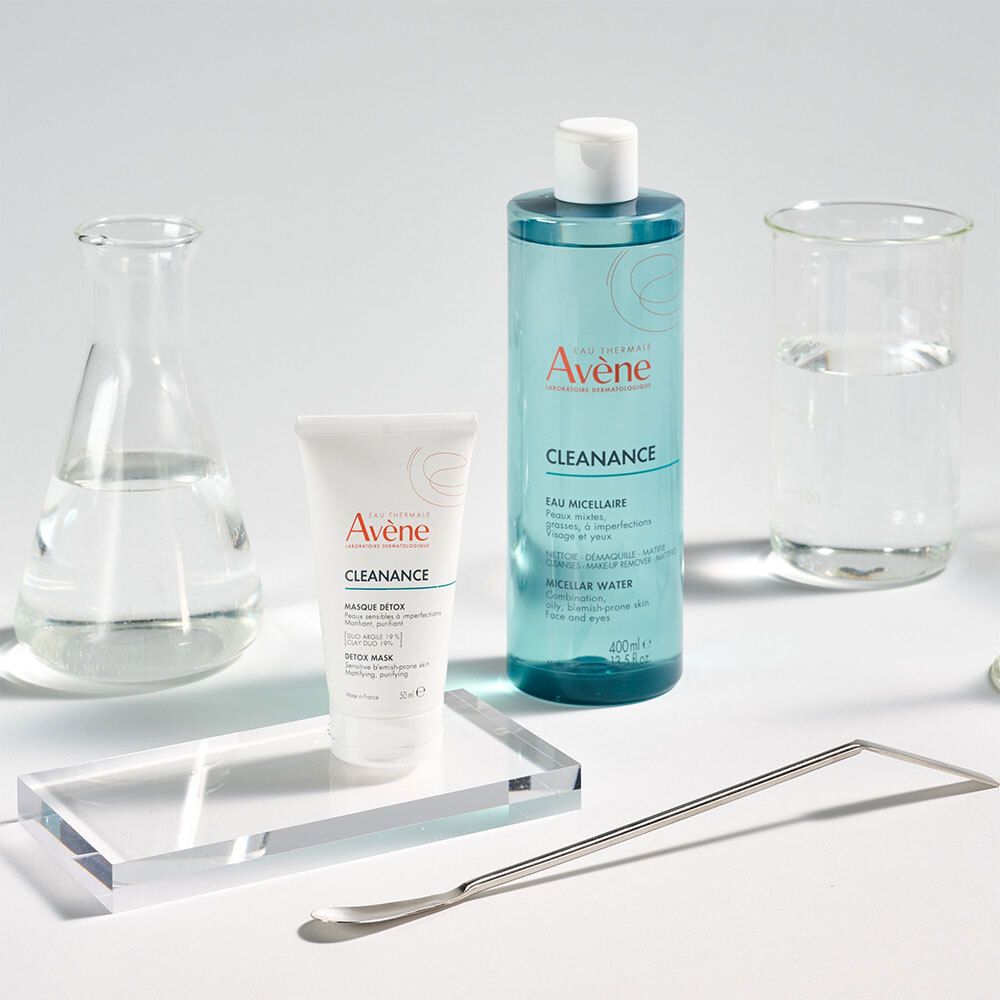 Verschiedene Laborutensilien und Avène Cleanance Produkte. Mizellenwasser, Creme, Spatel.