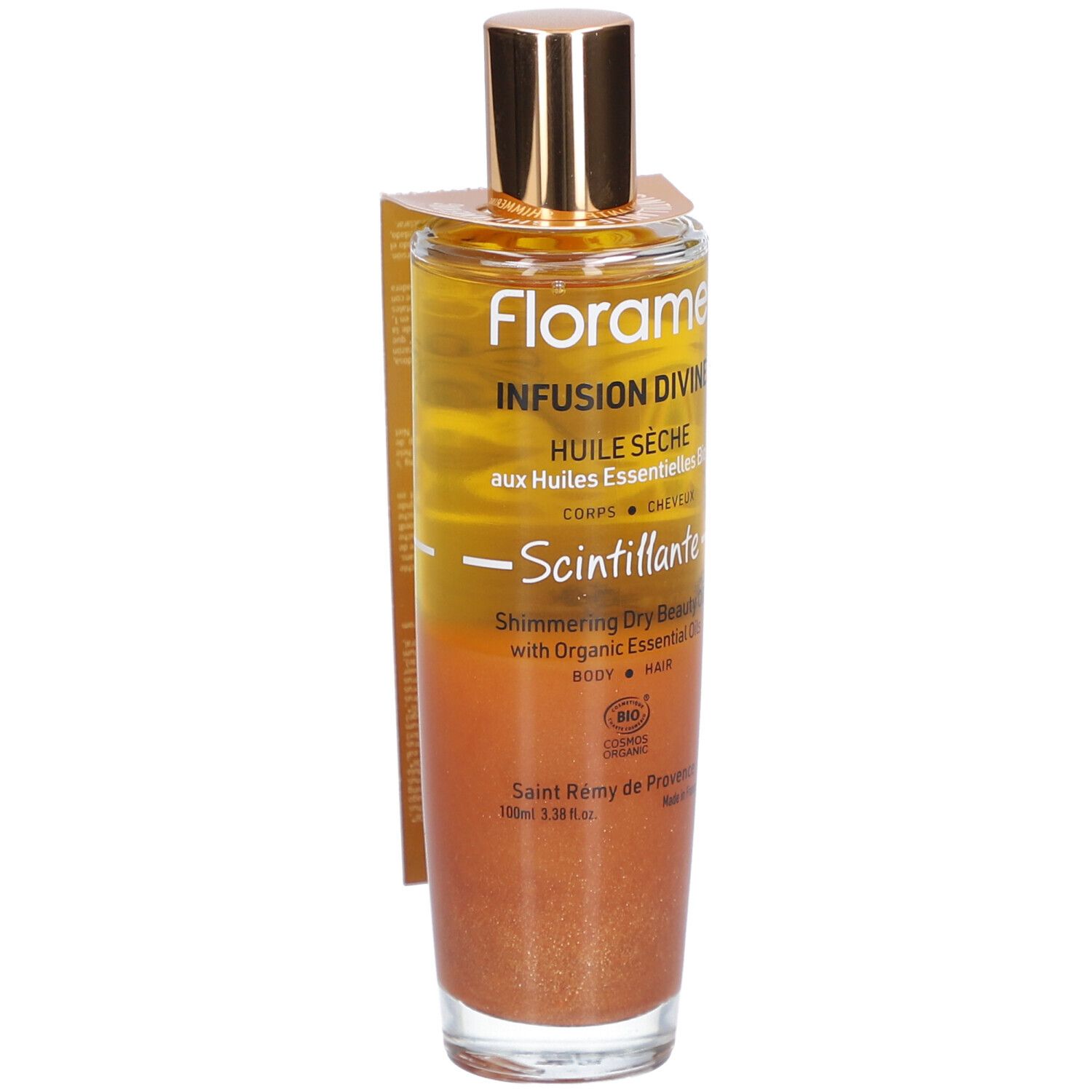 Flacon en verre avec bouchon doré. Étiquette avec nom et texte du produit. Liquide aux tons or et bronze.