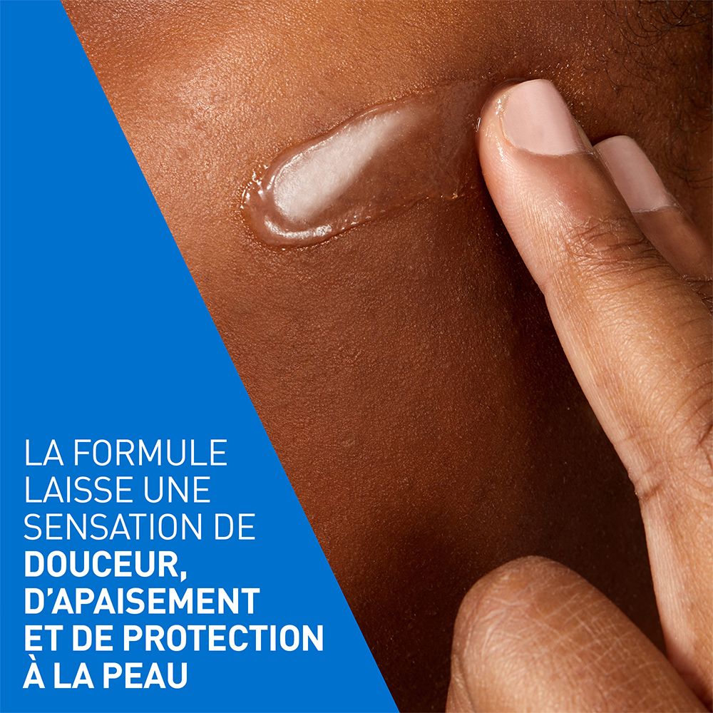 Gros plan d'une main appliquant une crème sur la peau. La crème est blanche et brillante.