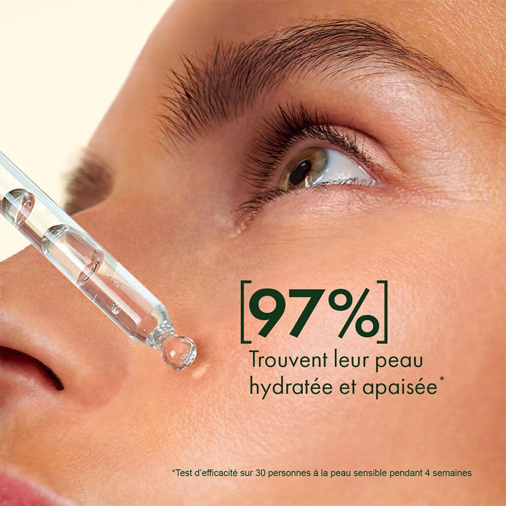 Nahaufnahme eines Gesichts. Pipette mit Serum. Text: [97%] Trouvent leur peau hydratée et apaisée. Getestet an empfindlicher Haut.