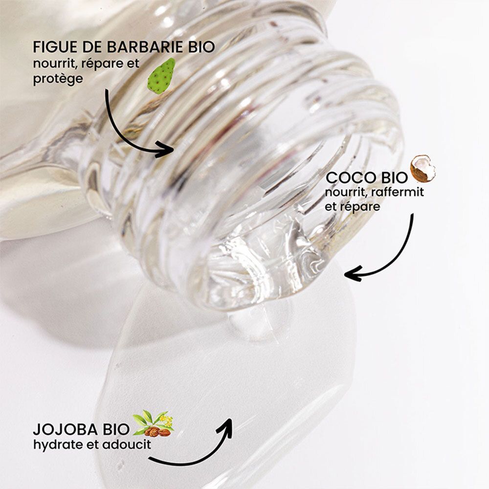 Gros plan de l'ouverture du flacon. Flèches pointant vers les ingrédients : figue de barbarie, noix de coco et jojoba. Liquide transparent.