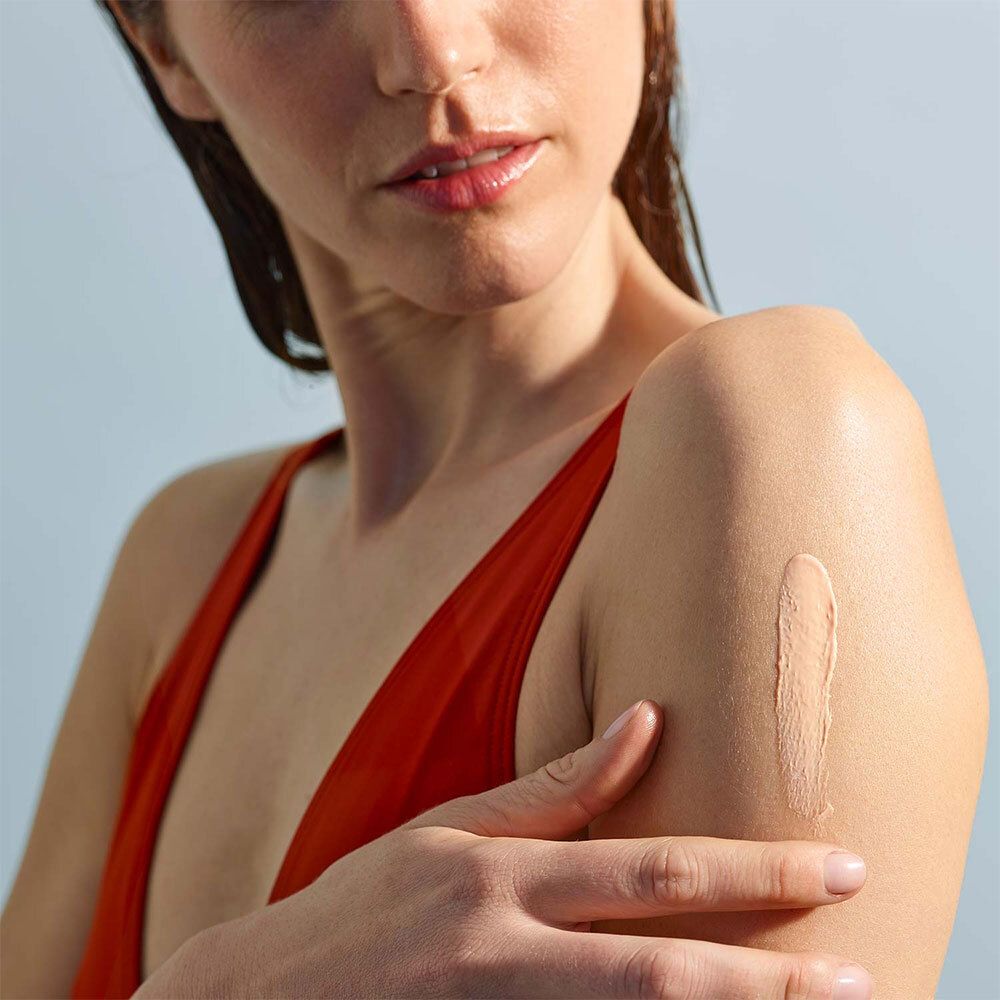 Person trägt Sonnencreme auf den Arm auf. Text: LABORATOIRES DE BIARRITZ, 50 SPF, Lait Solaire Invisible.