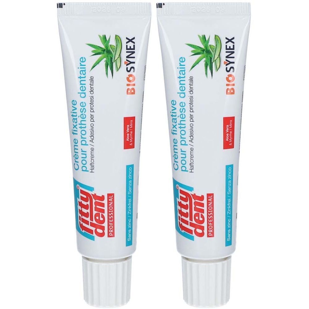 Deux tubes de crème fixative Fittydent Professional. Tubes blancs avec texte bleu et rouge. Texte: Crème fixative pour prothèse dentaire.