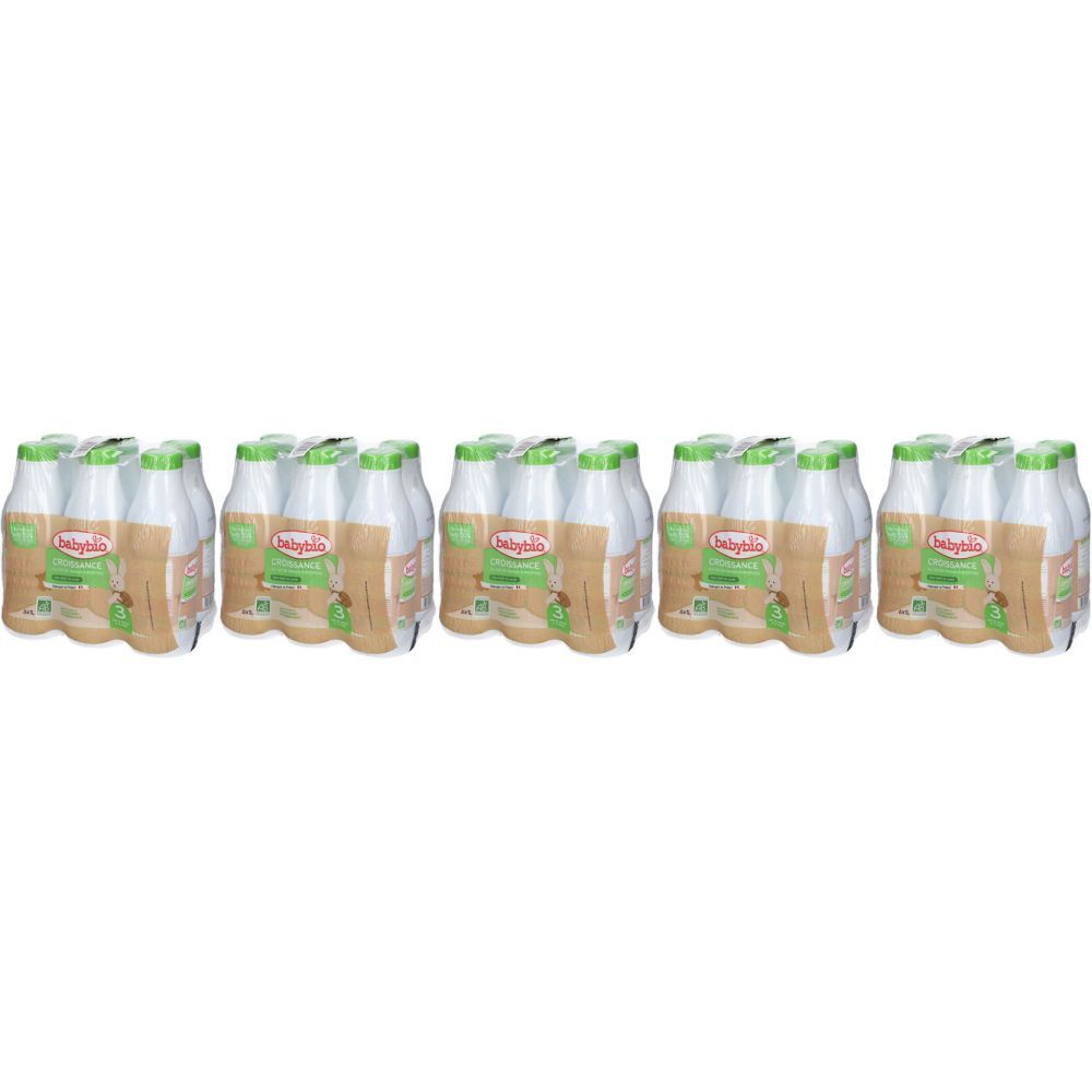 Plusieurs packs de lait pour bébé. Chaque pack contient des bouteilles avec des bouchons et étiquettes verts et blancs.