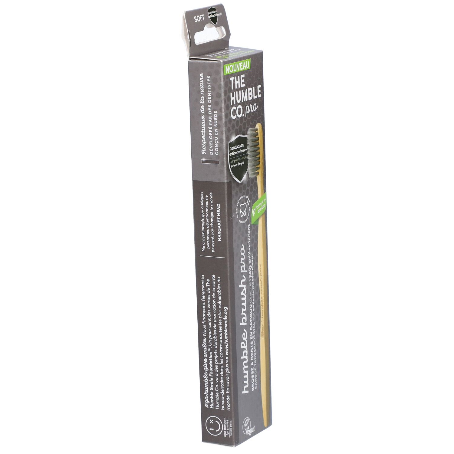 Brosse à dents dans son emballage. Manche en bambou, poils gris. Nom et logo du produit sur l'emballage.