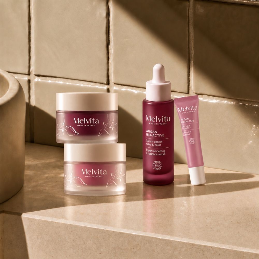 Drei Melvita-Produkte: zwei Cremetiegel und eine Pipettenflasche, daneben eine kleine Tube.