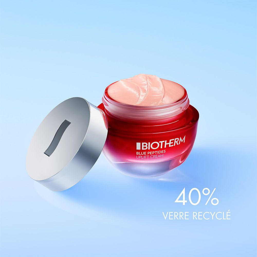 Pot rouge avec couvercle argenté, ouvert. Inscription : BIOTHERM, BLUE PEPTIDES. Texte : 40% verre recyclé.