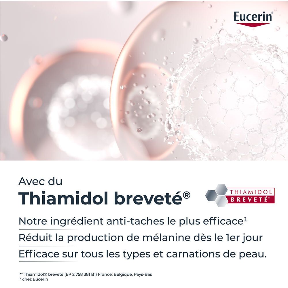 Gros plan de deux sphères. Texte: Avec du Thiamidol. Réduit la production de mélanine dès le 1er jour.