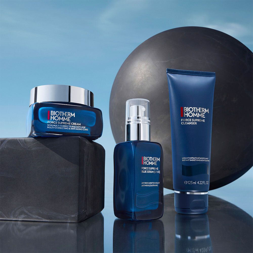 Trois produits Biotherm Homme : crème, sérum, nettoyant. Emballage bleu, fond noir.