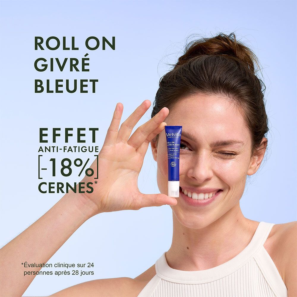 Frau hält Melvita Roll-On mit Kornblumenwasser vor das Auge.