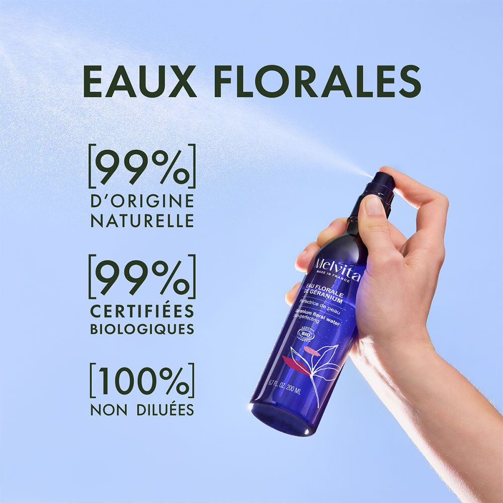 Hand hält eine blaue Sprühflasche. Text: 99% natürlichen Ursprungs, 99% biologisch zertifiziert, 100% unverdünnt. Melvita Logo.