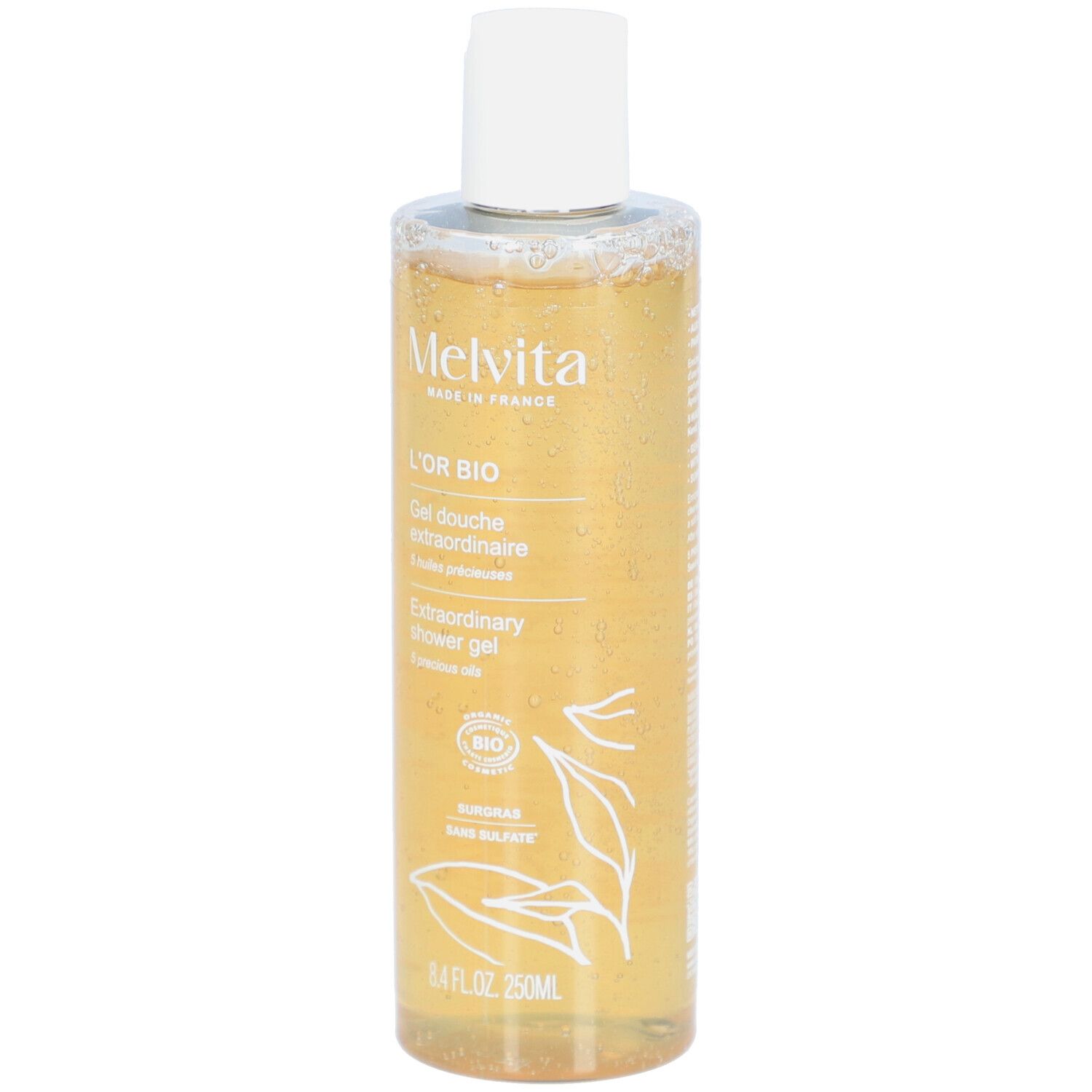 Melvita L'Or Bio Gel Douche Extraordinaire. Transparente Flasche mit gelbem Inhalt. Weißer Deckel. Bio-Siegel.
