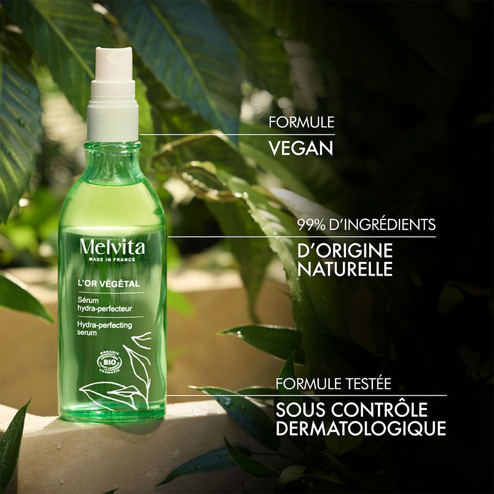 Serumflasche vor Blättern. Text: Vegane Formel. 99% natürliche Inhaltsstoffe. Dermatologisch getestet.