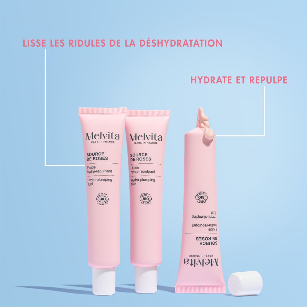 Drei rosa Tuben Melvita Source de Roses. Eine Tube mit Produkt, eine mit Produkt, eine mit Produkt herausgedrückt.