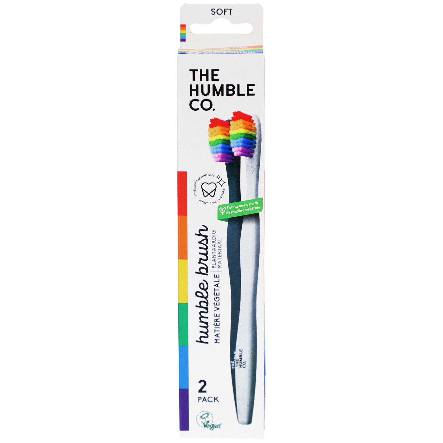 Zahnbürsten-Packung mit zwei Bürsten. Regenbogenfarbene Borsten, weißer Griff. Marke: The Humble Co.