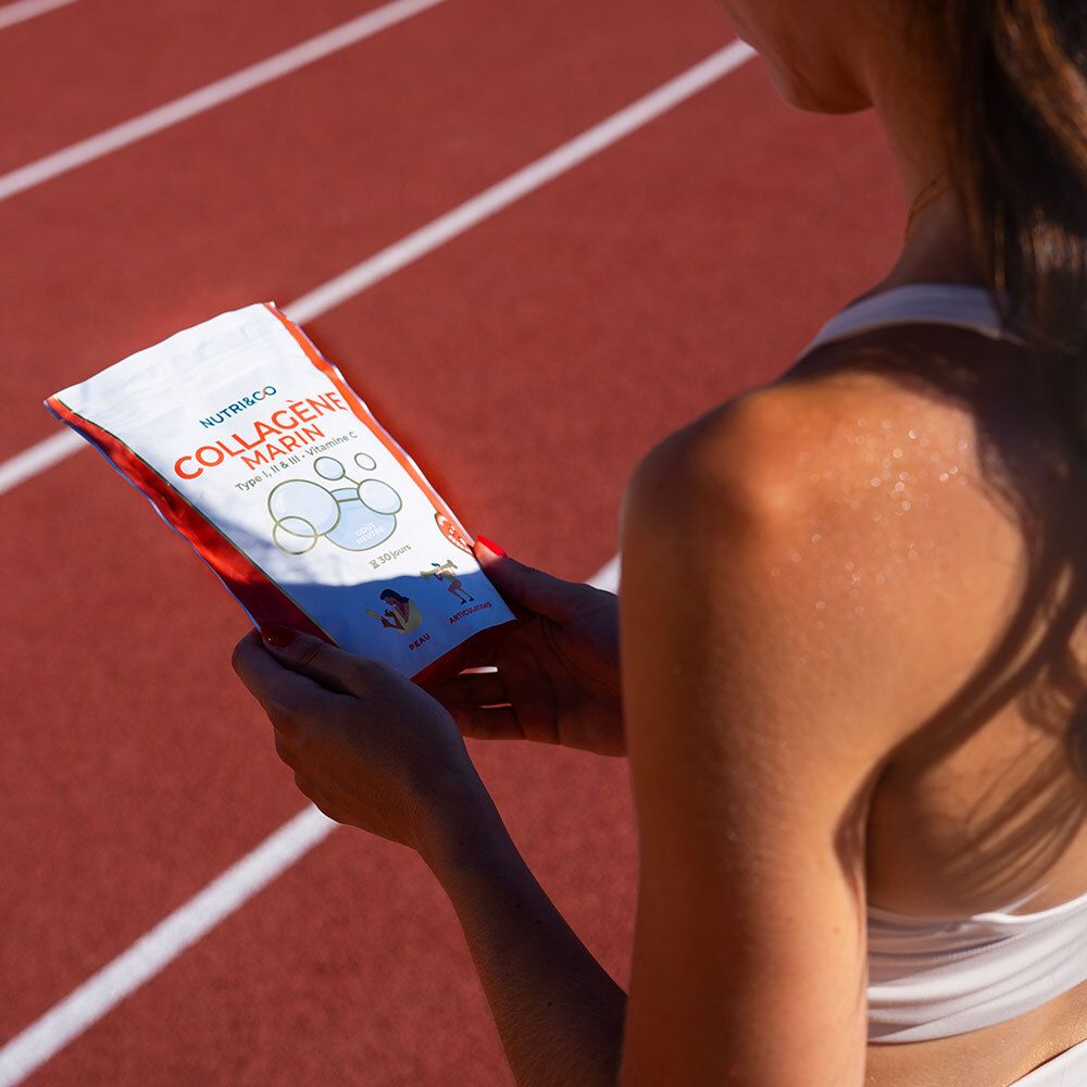Personne tenant un sachet de Collagène Marin NUTRI&CO. La personne est sur une piste d'athlétisme rouge.