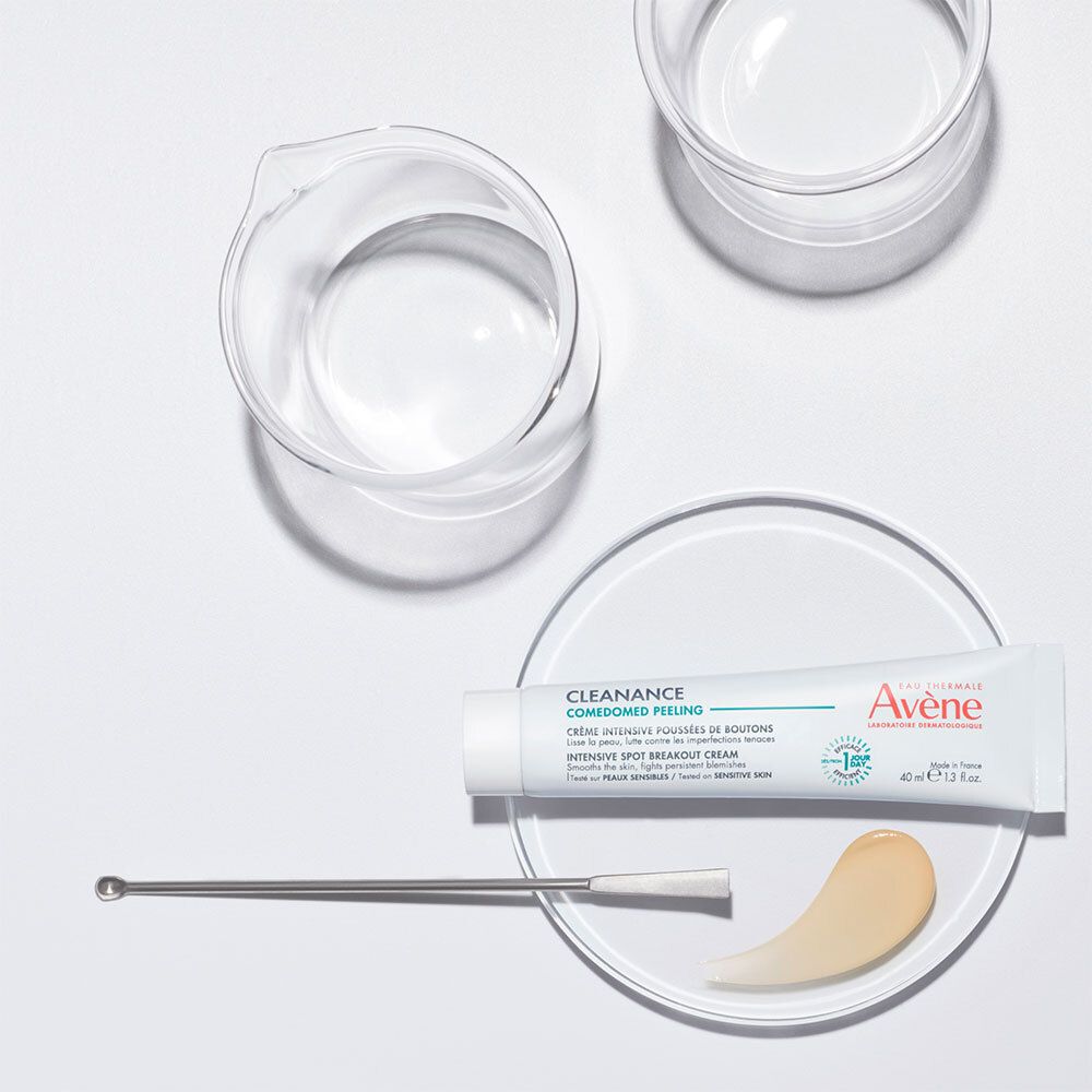 Tube, crème et ustensiles sur plaque blanche. Tube blanc avec nom du produit et marque.