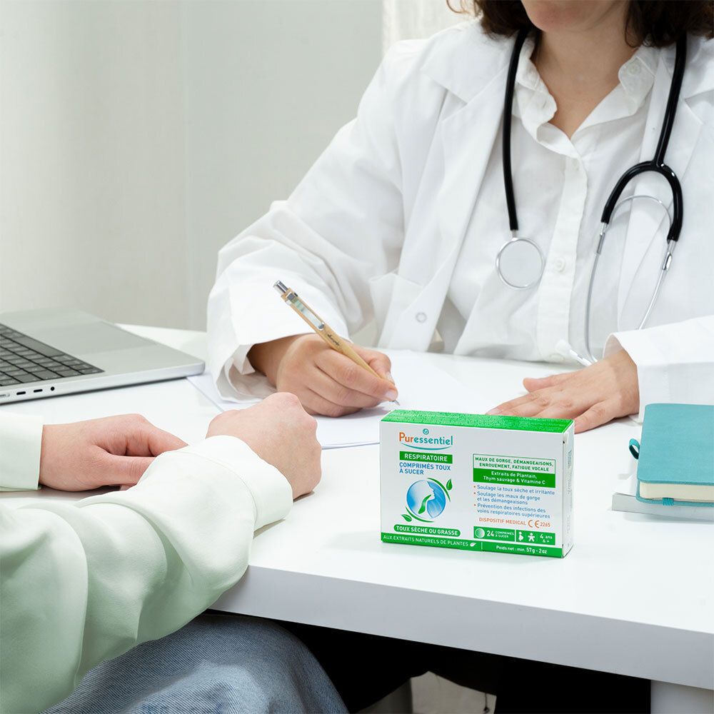 Médecin et patient à une table. Boîte de comprimés pour la toux. Texte: Puressentiel Respiratoire, Toux sèche ou grasse.