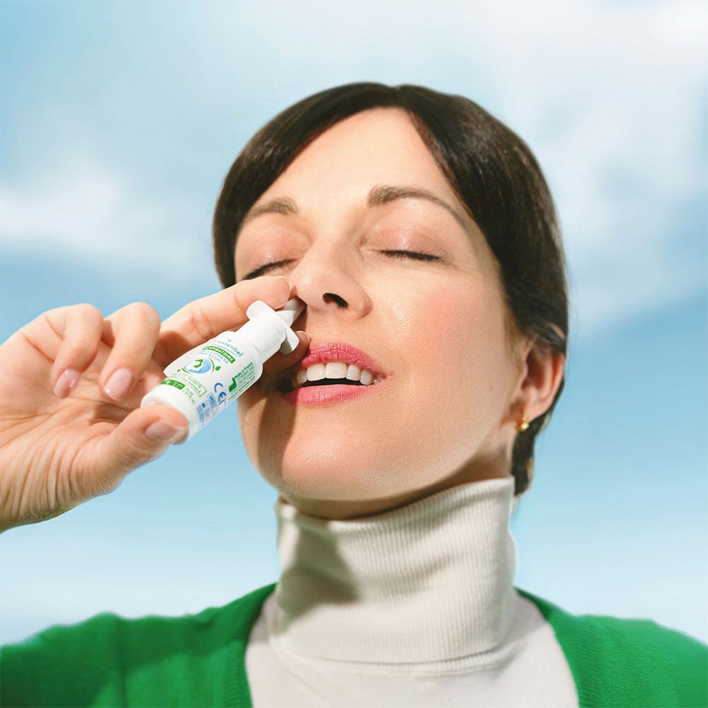 Femme tenant un spray nasal. Inscription : Puressentiel Respiratoire Sinus Express Spray Nasal. La femme porte un pull vert.