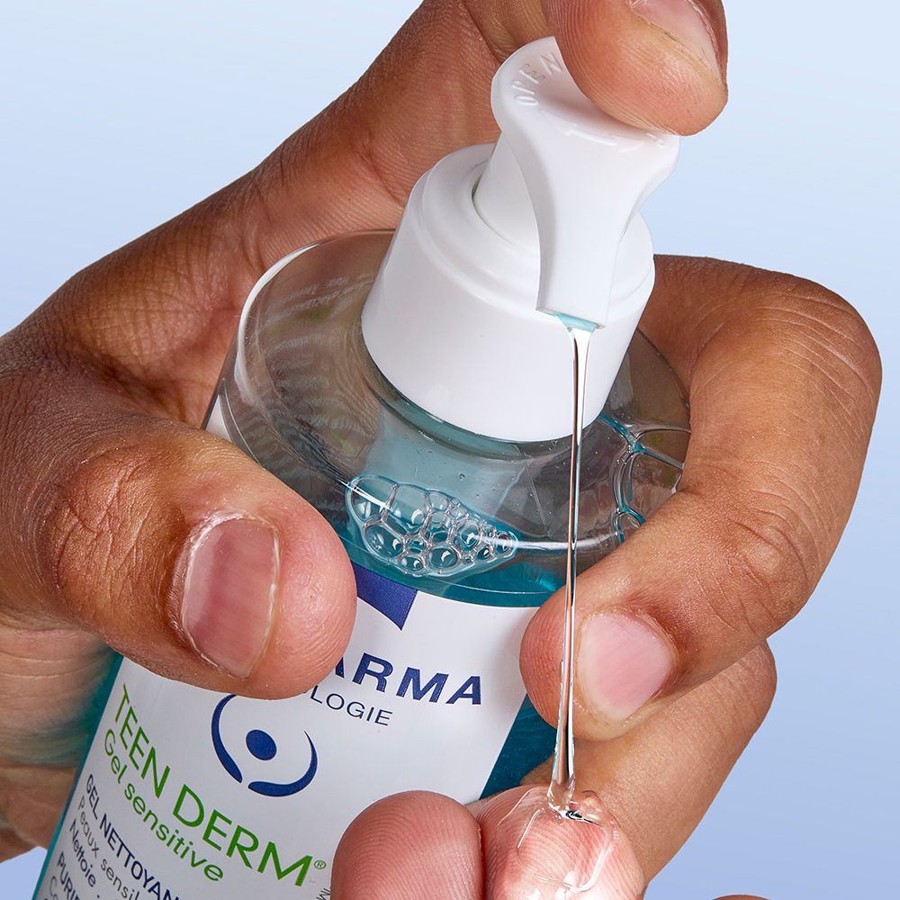 Hand drückt auf einen Pumpverschluss, Gel tropft heraus. Aufschrift: Teen Derm Gel Sensitive.