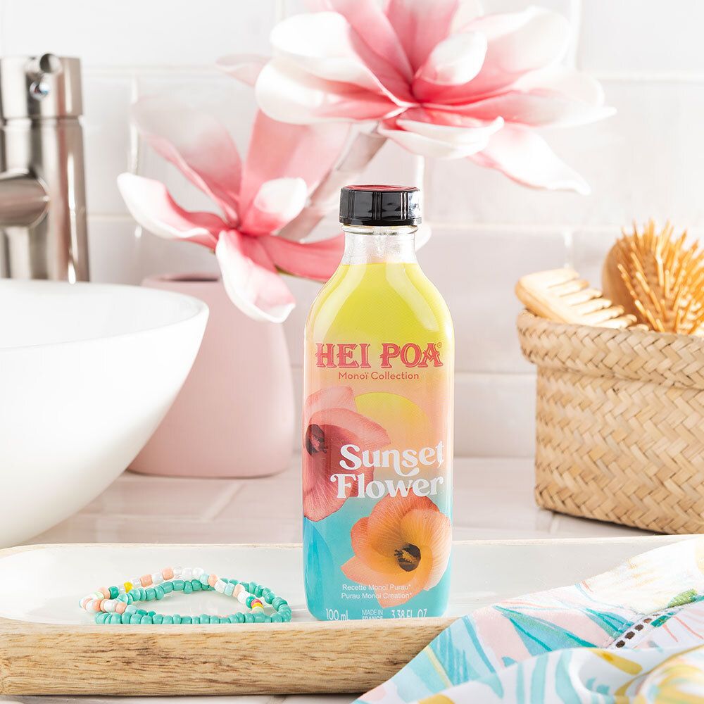 Flasche HEI POA Monoi Sonnenuntergang Blume auf Tablett. Badezimmer-Szene mit Accessoires. Schwarzer Deckel.