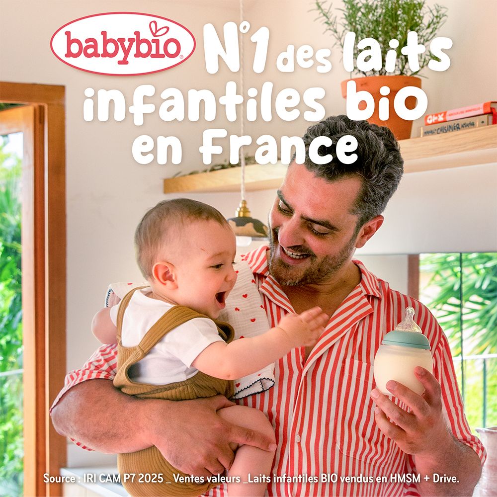 Biberon de lait tenu par un homme portant un bébé. Logo Babybio en haut à gauche.
