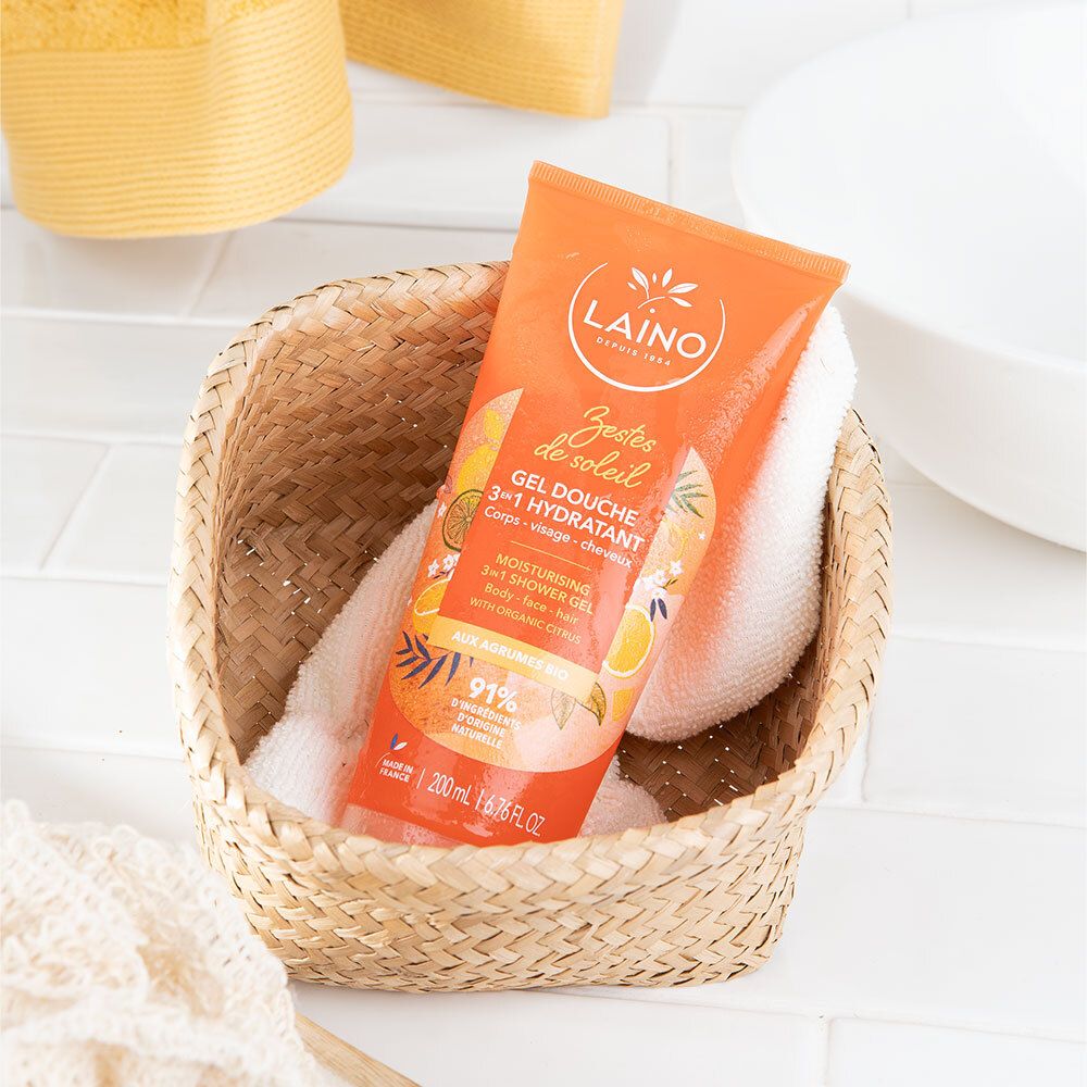LAINO Dusch-Shampoo 3in1 Zitrusfrüchte BIO Flasche in einem geflochtenen Korb mit Handtüchern.