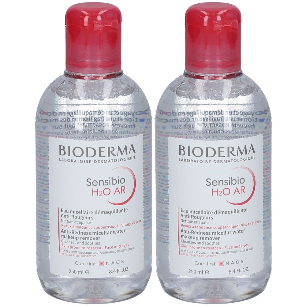 Deux flacons de Bioderma Sensibio H2O AR. Liquide clair dans des bouteilles transparentes avec bouchon rouge. Étiquette avec texte.
