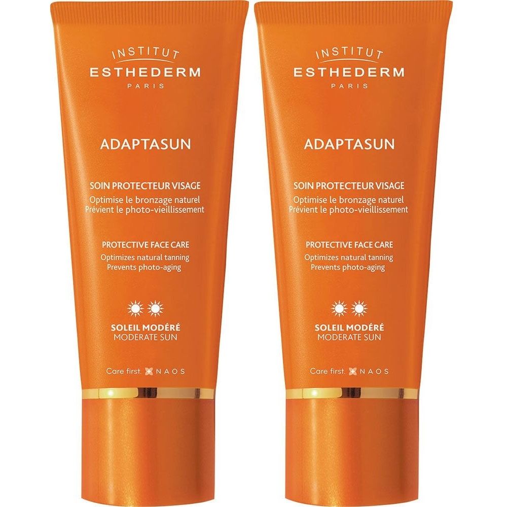 Deux tubes Adaptasun orange. Inscriptions: INSTITUT ESTHEDERM, SOIN PROTECTEUR VISAGE, SOLEIL MODÉRÉ. Texte en anglais et français.