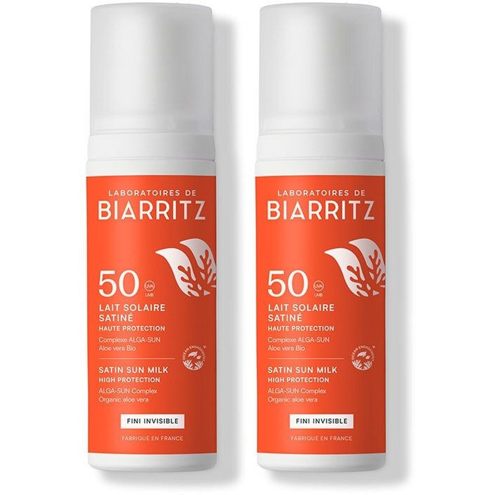 Zwei Flaschen Sonnenschutzmittel mit weißem Deckel und orangefarbenem Etikett. Aufschrift: Laboratoires de Biarritz, Lait Solaire Satiné SPF 50.
