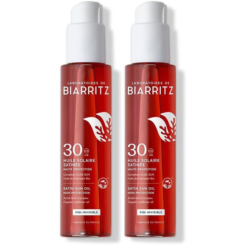 Zwei Flaschen Sonnenöl mit weißem Pumpkopf. Aufschrift: Laboratoires de Biarritz, 30, Huile Solaire Satinée, Fini Invisible.