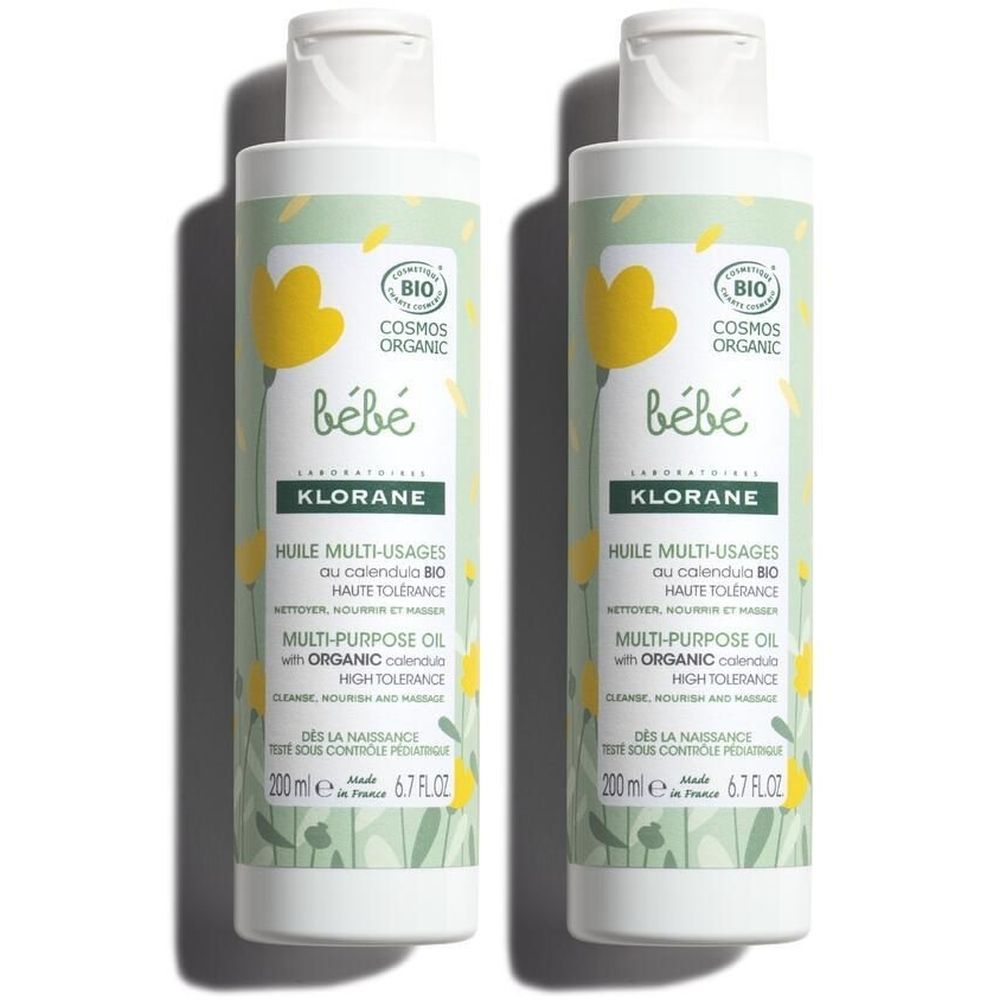 Zwei Flaschen Babyöl. Weißer Flaschenkörper mit gelbem Etikett. Aufschrift: „bébé“, „KLORANE“, „Huile multi-usages“. Bio-Zertifizierung.
