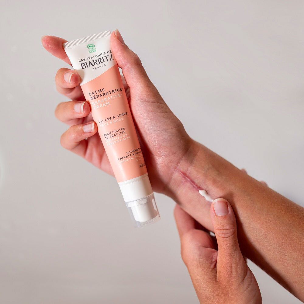 Nahaufnahme einer Hand mit einem Streifen Creme. Die Creme ist weiß und liegt auf der Haut.