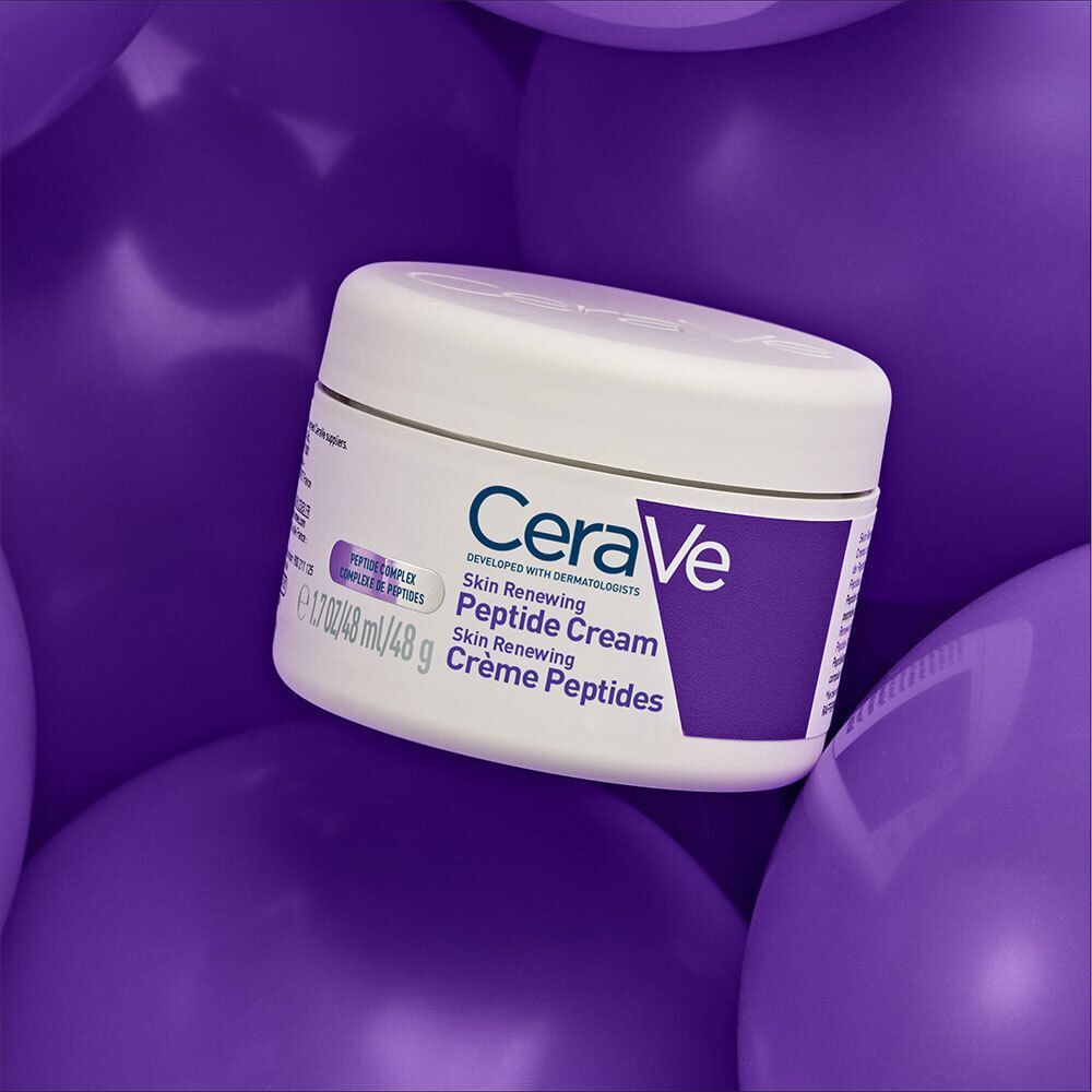 Pot blanc avec accents violets sur fond violet. Inscription : CeraVe Skin Renewing Peptide Cream.