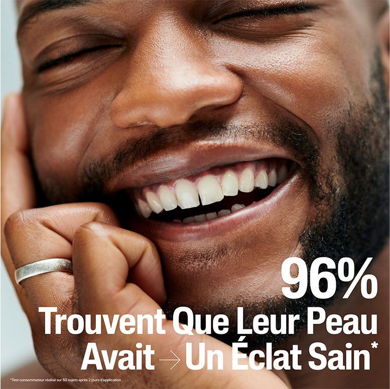 Gros plan d'un homme souriant avec texte : 96% trouvent que leur peau avait un éclat sain.