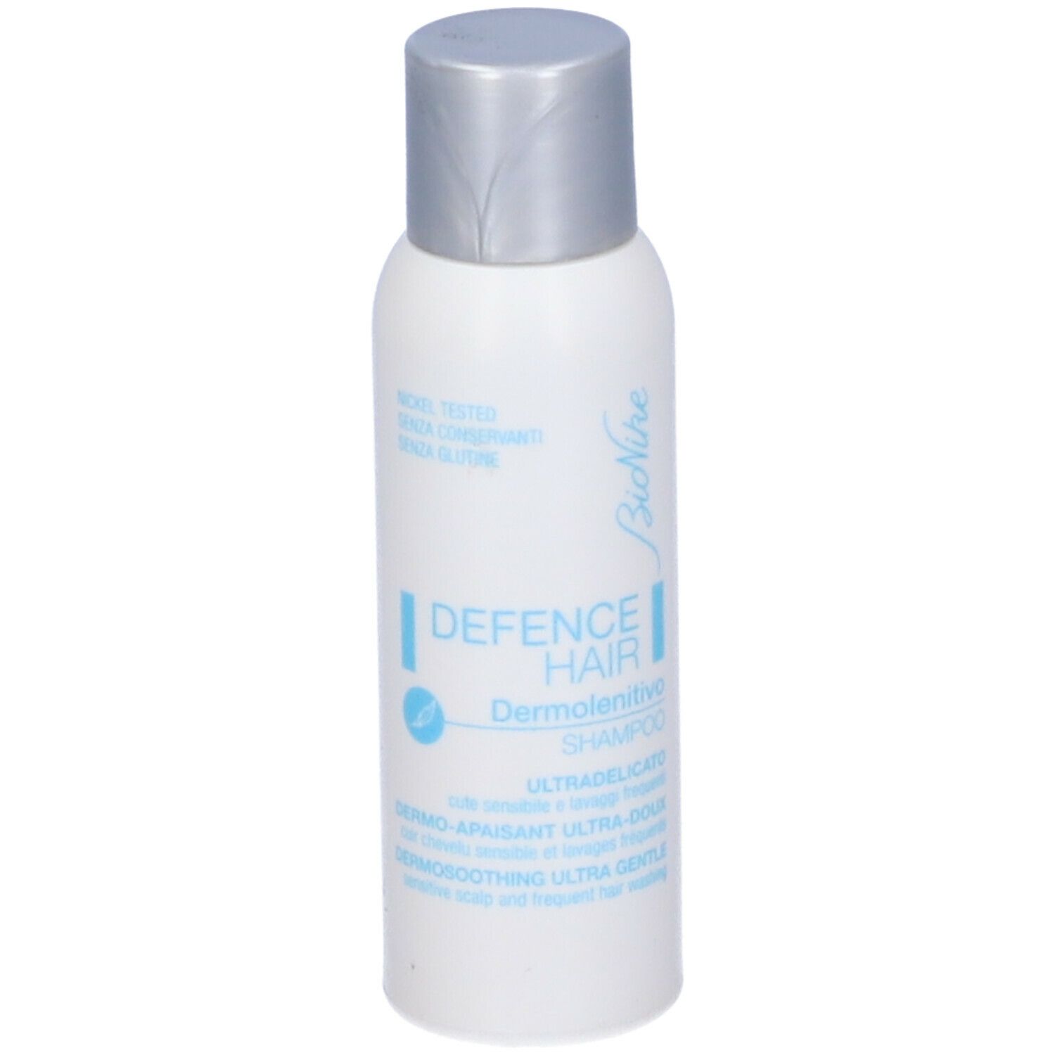 Flacone bianco, tappo argento. Testo: Bionike, Defence Hair, Dermolenitivo Shampoo. Nickel tested.