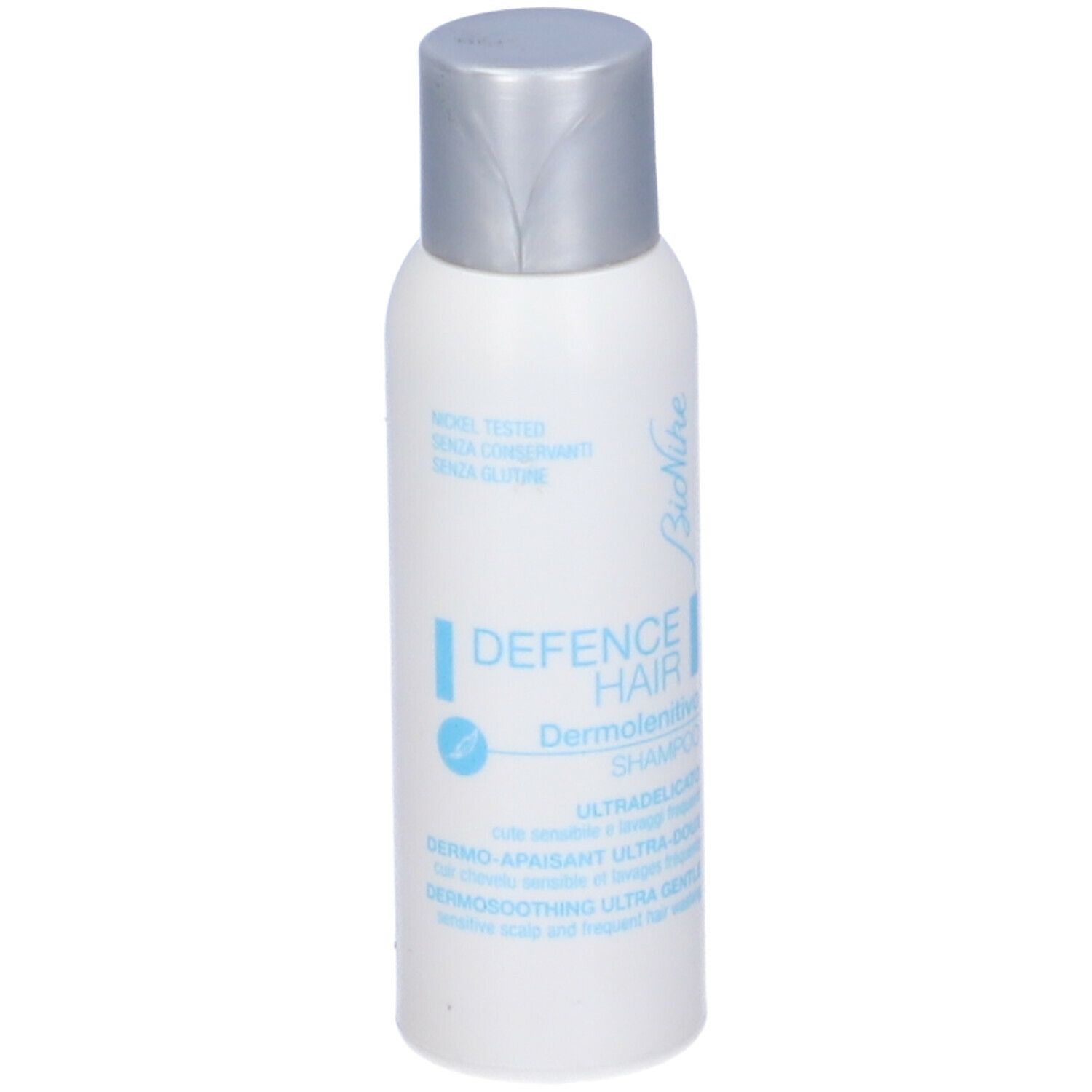 Flacone bianco, tappo argento. Testo: Bionike, Defence Hair, Dermolenitivo Shampoo. Nickel tested.