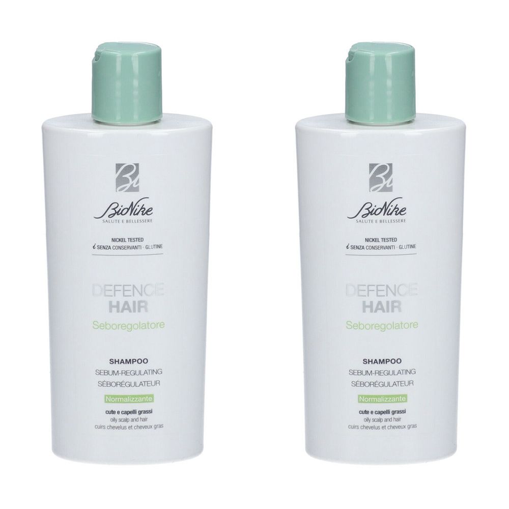 Due flaconi bianchi con tappo verde. Scritta: Defence Hair Shampoo, Seboregolatore. Marchio: BioNike.