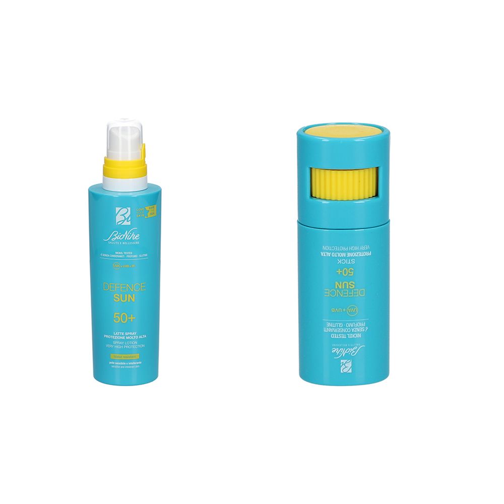 Due contenitori blu di crema solare. A sinistra, flacone spray con tappo giallo. A destra, stick con tappo rotante giallo. SPF 50+.