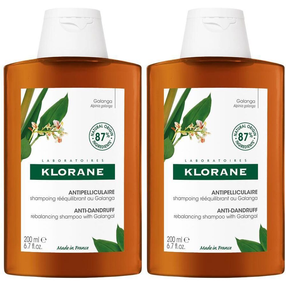 Due flaconi marroni di shampoo KLORANE antiforfora con tappo bianco. Etichetta con informazioni sul prodotto e logo.