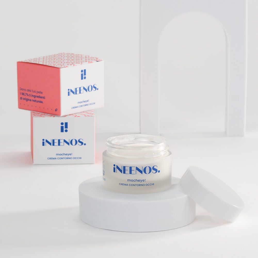 Vasetto di crema e due confezioni. Scritta: iNEENOS. mocheye! CREMA CONTORNO OCCHI. Base bianca.
