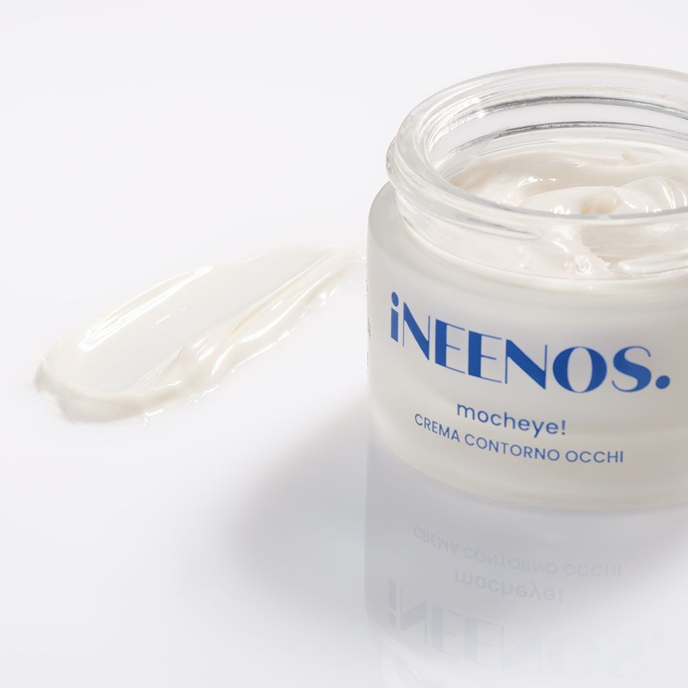 Vasetto di crema e strato di crema. Scritta: iNEENOS. mocheye! CREMA CONTORNO OCCHI. Sfondo bianco.