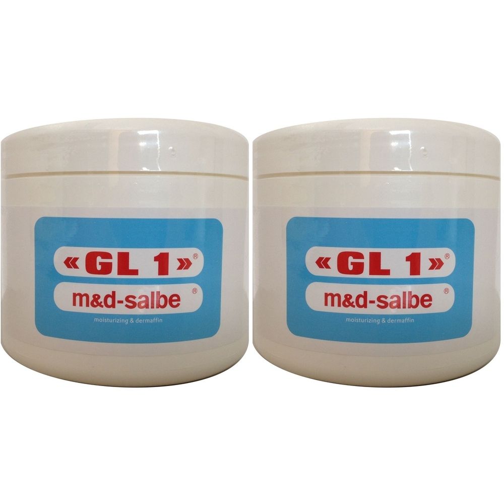 Due vasetti color crema con coperchi. Etichette blu con «GL 1» m&d-salbe. Idratante e lenitivo.